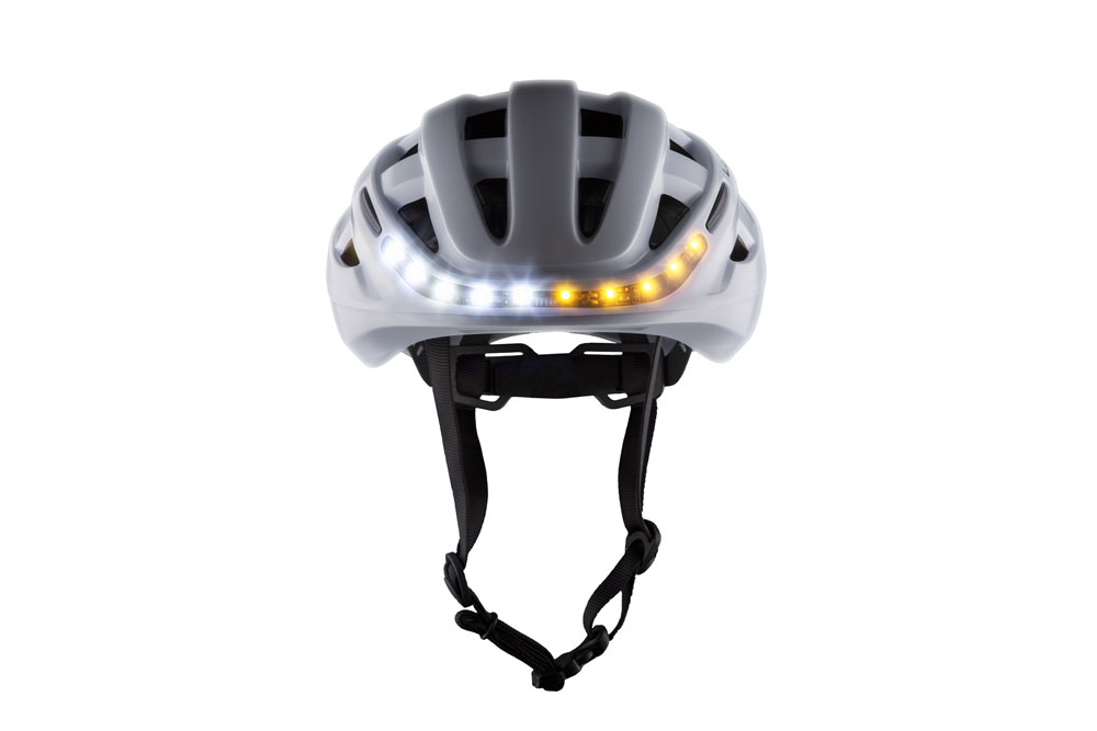 White Lumos Kickstart bike helmet with front lights on White Lumos Kickstart bike helmet with front lights on