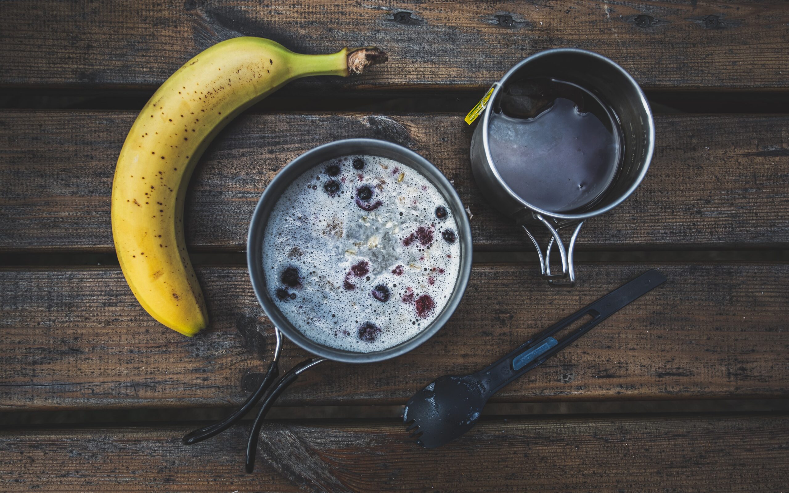 Banana, tea, pot with cereals and reusable plstic spun in a woden table