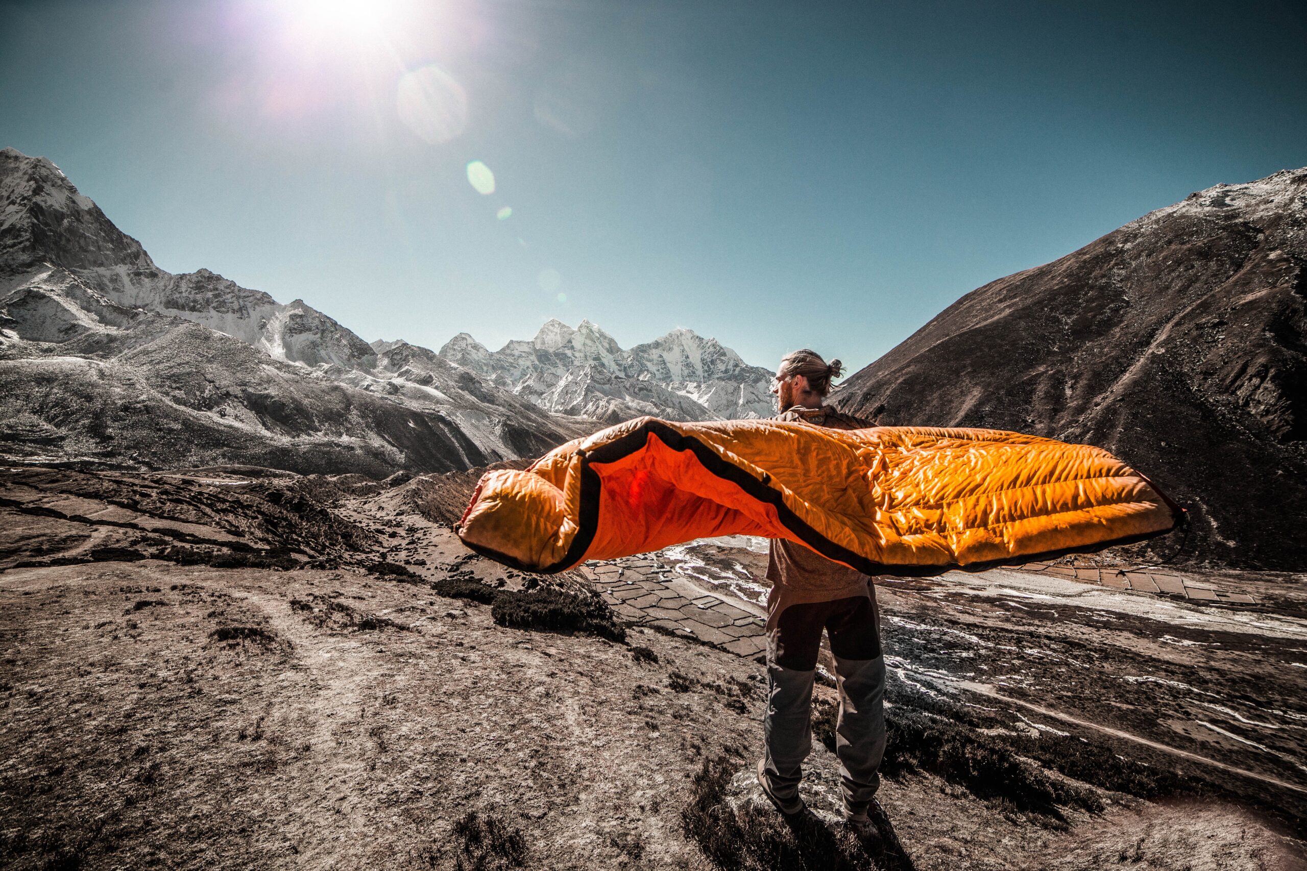 Man holding a sleeping bag in the mountain