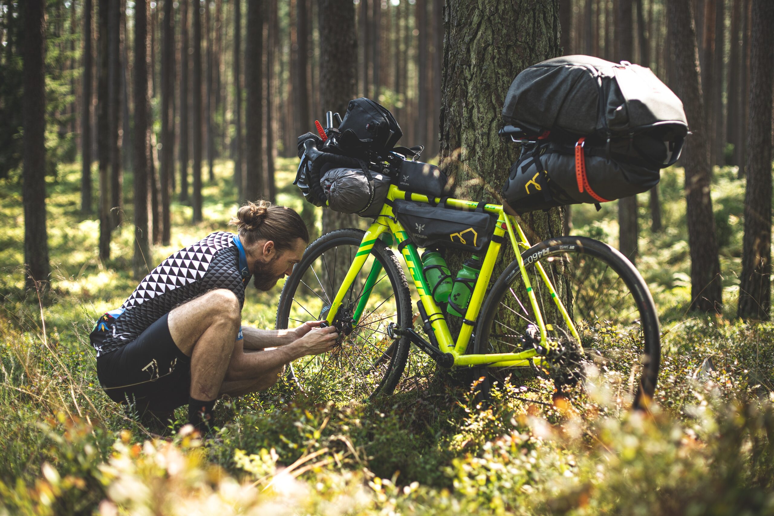 Man with a bicycle ready and equipped for bikepacking - Photo by Marek Piwnicki on Unsplash