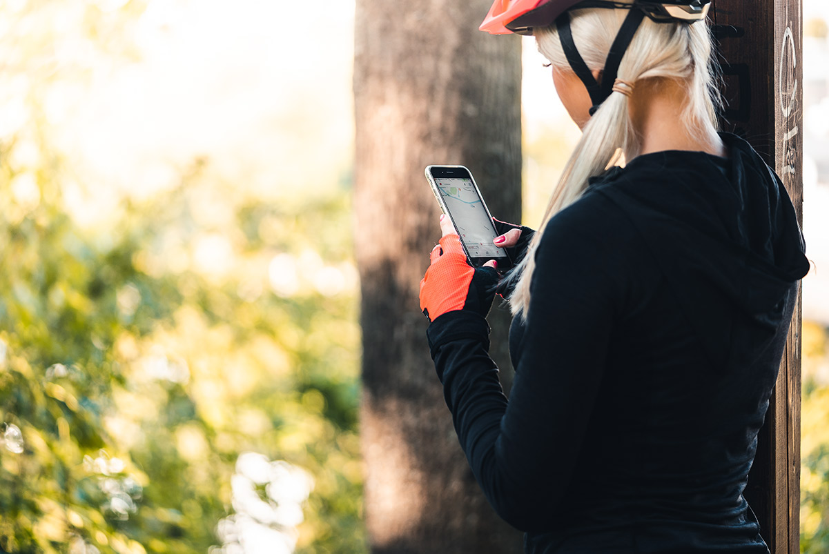 Woman checking a cyclist App on her phone Woman checking a cyclist App on her phone