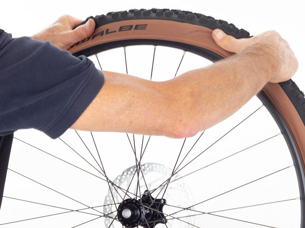 Pull bicycle tyre over rim