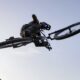 Cyclist jumps over an obstacle with a Cube 2026 bike in front of a waterfall.