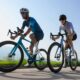 Two road cyclists (male and female) riding a 2026 Cube road bike in motion.