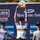Finn Treudler celebrates at the Cube Factory Racing Season Finale 2025 in Mont-Sainte-Anne, holding the trophy aloft, flanked by the second- and third-place riders on the podium.